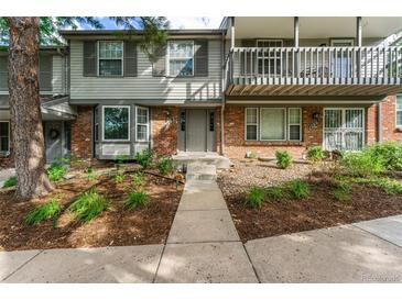 Two-story townhome with brick and siding exterior, landscaping, and a walkway at 7114 E Briarwood Dr, Centennial, CO 80112