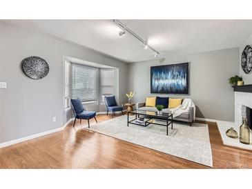 Cozy living room with a bay window, hardwood floors, and stylish decor, perfect for relaxation and entertaining at 7114 E Briarwood Dr, Centennial, CO 80112