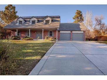 Charming brick home featuring a large front yard, attached garage, and solar panels at 6889 Frying Pan Rd, Boulder, CO 80301