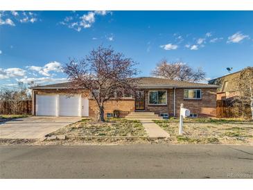 Brick front ranch home with an attached two-car garage and a concrete walk way up to the front door at 6095 W 47Th Ave, Wheat Ridge, CO 80033