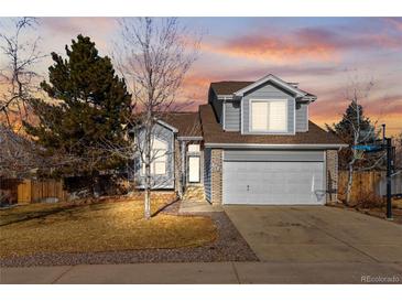 Two-story house with attached garage and landscaped yard at 5418 S Fundy Cir, Centennial, CO 80015