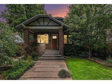 Charming brick home featuring a landscaped front yard and inviting porch at 3019 Meade St, Denver, CO 80211