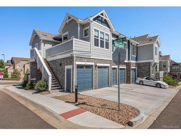Attractive townhome with stone accents, multiple garages, and a welcoming stairway to upper-level unit at 5755 S Buchanan Ct # E, Aurora, CO 80016