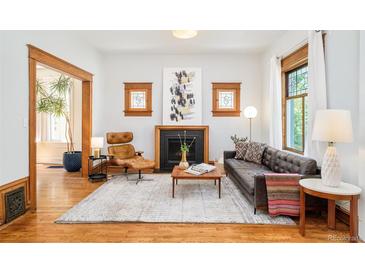 Bright living room features hardwood floors, fireplace, and large windows for natural light at 2228 N Race St, Denver, CO 80205