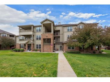 A beautiful exterior view of the building with a well-manicured lawn and blue skies above at 12816 Ironstone Way # 203, Parker, CO 80134