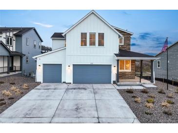 Charming two-story home featuring a modern farmhouse design with a two-car garage and covered porch at 875 Coal Bank Trl, Castle Rock, CO 80104