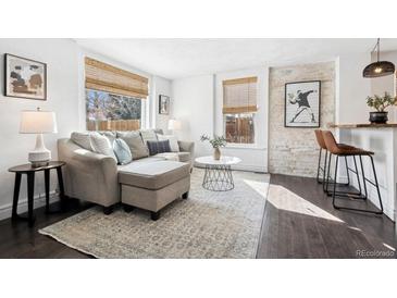 Bright living room with hardwood floors, large windows, and comfortable seating arrangement at 1535 Spruce St, Denver, CO 80220