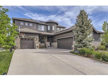 Beautiful home with a three-car garage, stone accents, and mature landscaping at 1495 W 137Th Ave, Broomfield, CO 80023