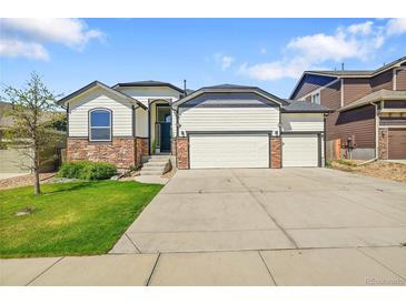 Charming home with a three-car garage, stone accents, and well-maintained lawn at 6829 Juniper Ct, Frederick, CO 80530