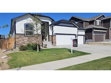 Charming home with a well-manicured lawn, stone accents, and an attached three-car garage at 6829 Juniper Ct, Frederick, CO 80530