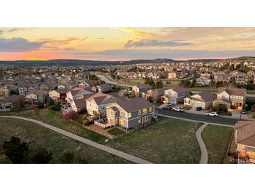 Stunning aerial view of the neighborhood at sunset, showcasing the home, streets and surrounding landscape at 1983 Candleglow St, Castle Rock, CO 80109
