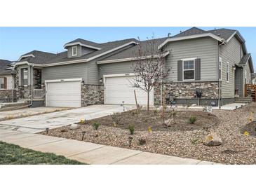 Charming townhome with stone accents, attached garages, and landscaped front yard at 3492 N Buchanan Way, Aurora, CO 80019
