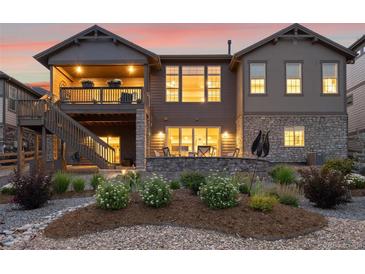 Two-story home with a large deck, landscaped backyard, and mountain views at 8234 Superior Cir, Littleton, CO 80125