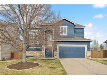 Charming two-story home with a blue exterior, stone accents, and a well-manicured lawn at 684 Poppy Pl, Highlands Ranch, CO 80129