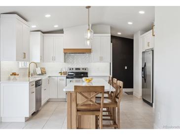 Bright kitchen features white cabinets, a large island, stainless steel appliances, and modern finishes at 10885 Longs Peak Ln, Parker, CO 80138