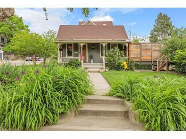 Charming front yard with lush greenery, flower beds, and a cozy porch with patriotic accents at 503 15Th St, Golden, CO 80401