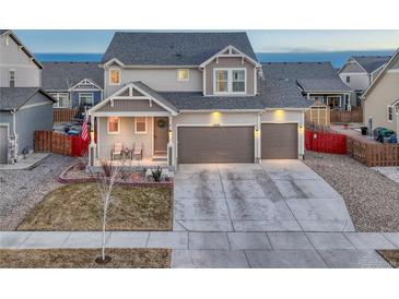 Charming two-story home with a three-car garage, covered porch, and well-maintained landscaping at 12988 E 108Th Pl, Commerce City, CO 80022