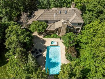 Stunning aerial view of the property featuring a pool, spa, patio, and lush landscaping at 5550 Preserve Dr, Greenwood Village, CO 80121