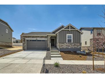 Charming single-Gathering home with stone accents, gray siding, a two-car garage, and a well-maintained front yard at 21964 E 39Th Ave, Aurora, CO 80019