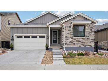 Charming gray home featuring a two-car garage, stone accents, and a well-maintained front yard at 9162 Star Streak Cir, Littleton, CO 80125