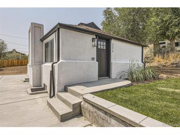 Charming home featuring a stylish front entrance, landscaped yard, and a unique chimney design at 3275 S Decatur St, Denver, CO 80236