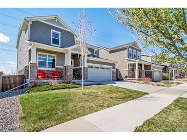Charming two-story home featuring a well-manicured lawn, covered porch, and inviting curb appeal at 17382 Bluetrail Ave, Parker, CO 80134