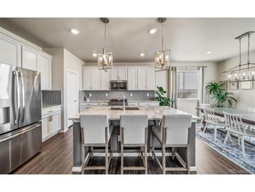 Modern kitchen with stainless steel appliances, granite counters, island and hardwood floors at 17382 Bluetrail Ave, Parker, CO 80134