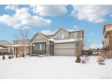 Two-story house with gray siding, stone accents, and a three-car garage at 7916 S Grand Baker Way, Aurora, CO 80016