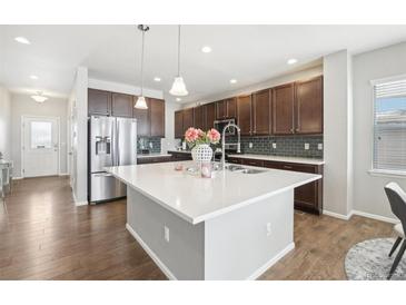 Modern kitchen with island, stainless steel appliances, and dark cabinets at 7916 S Grand Baker Way, Aurora, CO 80016