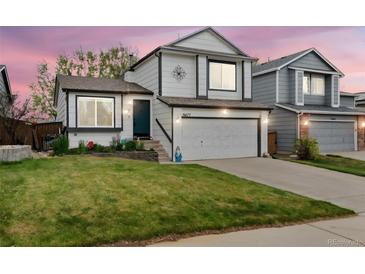 Charming two-story home features a well-manicured lawn, two-car garage, and inviting front entrance at 9677 Castle Ridge Cir, Highlands Ranch, CO 80129