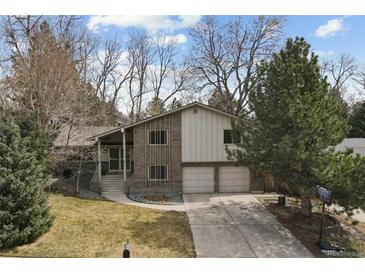Charming two-story brick home with a well-manicured lawn and a two-car garage at 2492 S Yarrow St, Lakewood, CO 80227
