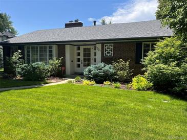 Charming brick home with well-maintained lawn and mature landscaping, creating inviting curb appeal at 701 S Clayton St, Denver, CO 80209