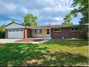 Charming brick home with a well-maintained lawn and attached two-car garage at 13024 E Alaska Pl, Aurora, CO 80012