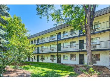 Three-story apartment building with black iron railings and lush greenery in a well-maintained yard at 5995 E Iliff Ave # 106, Denver, CO 80222