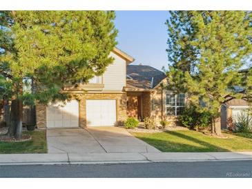 Charming two-story home with brick accents, attached two-car garage, and mature landscaping at 10961 Main Range Trl, Littleton, CO 80127