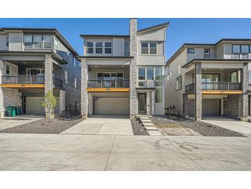 Modern townhome with stone accents, a covered balcony, and an attached garage, showcasing its contemporary design at 3147 S Russell St, Morrison, CO 80465