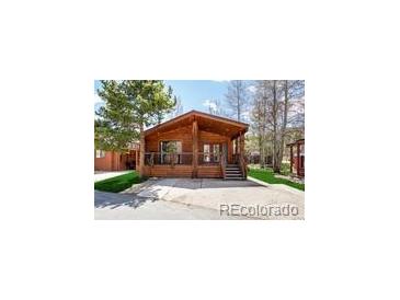 Charming cabin-style home featuring a covered porch and wooden accents in a serene, natural setting at 85 Revett Dr # 66, Breckenridge, CO 80424