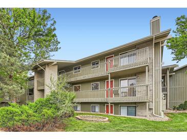 Three-story condo building featuring red entry doors and wood railings overlooking manicured landscaping at 695 Manhattan Dr # 109, Boulder, CO 80303