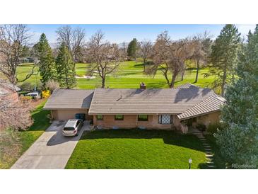 Charming single-story brick home featuring a large driveway and adjacent golf course views for a relaxing backdrop at 16 Wedge Way, Littleton, CO 80123