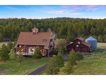 Stunning exterior view of home with mature trees and well-maintained landscaping at 11689 Caribou Dr, Franktown, CO 80116