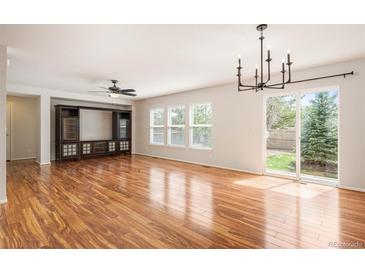Spacious living room featuring hardwood floors, a ceiling fan, and a sliding door to the backyard at 5875 Raleigh Cir, Castle Rock, CO 80104