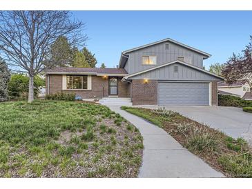 Charming two-story home boasts a well-manicured front yard and inviting walkway at 7380 Tabor St, Arvada, CO 80005