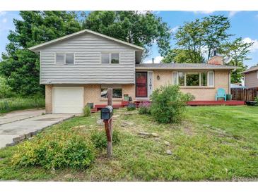 Charming two-story home with a brick and wood facade, and a well-maintained front yard and inviting front porch at 1161 S Johnson Way, Lakewood, CO 80232