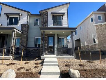 Two-story townhome with gray siding and stone accents at 6608 N Nepal Ct, Aurora, CO 80019