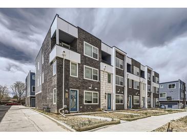 Modern townhome exterior featuring brick and white siding, balconies, and inviting blue front doors at 348 N Geneva St, Aurora, CO 80010