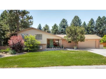 Ranch style home with brick facade, attached garage, and well-manicured lawn at 4600 W Princeton Ave, Denver, CO 80236