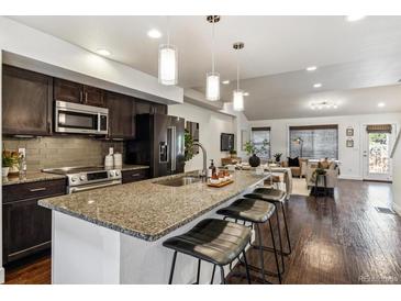 Modern kitchen features a large island with bar seating, dark cabinets, and stainless steel appliances at 409 Terry St # D, Longmont, CO 80501