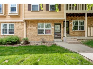 Inviting brick townhome with manicured lawn and charming architectural details at 338 Pheasant Run, Louisville, CO 80027