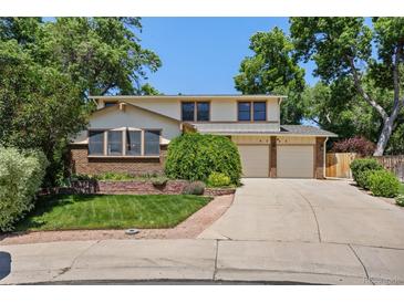 Charming two-story home with a well-manicured lawn, mature trees, and a two-car garage at 9025 Jellison Ct, Broomfield, CO 80021