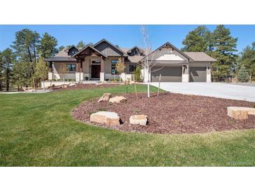 Beautiful home showcasing a well-manicured lawn and a three-car garage at 5787 Powell Rd, Parker, CO 80134